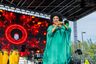 Female performer in green singing at the Three Kings Parade
