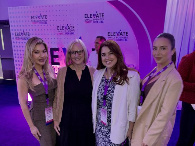Mayor Eileen Higgins and attendees posing together in front of the Elevate Small Business backdrop