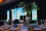El escenario principal de la Gala de BLUE Missions enmarcado con palmeras tropicales y mesas para cenar