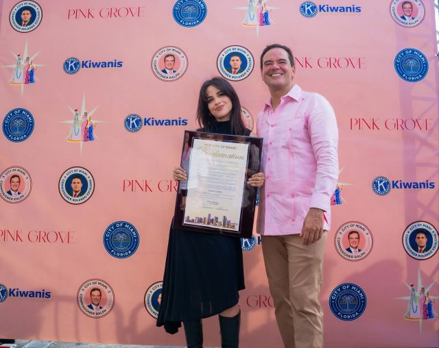 Camila Cabello and a City of Miami commissioner holding a proclamation at the Three Kings Parade